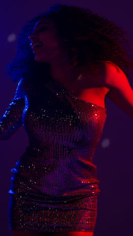 Vertical-Video-Of-Young-Woman-In-Nightclub-Bar-Or-Disco-Dancing-With-Sparkling-Lights-In-Background-7